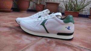 Deportiva de mujer hecha con materiales veganos en color blanco y verde y que llevan una suela de Tr con spoiler trasero.