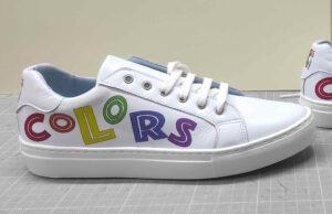 Deportiva de mujer de piel con detalles estampados de letras de colores. Vista lateral.